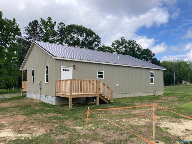 back of house with a deck and a yard