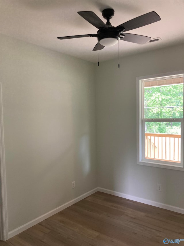 empty room with dark wood-type flooring and ceiling fan