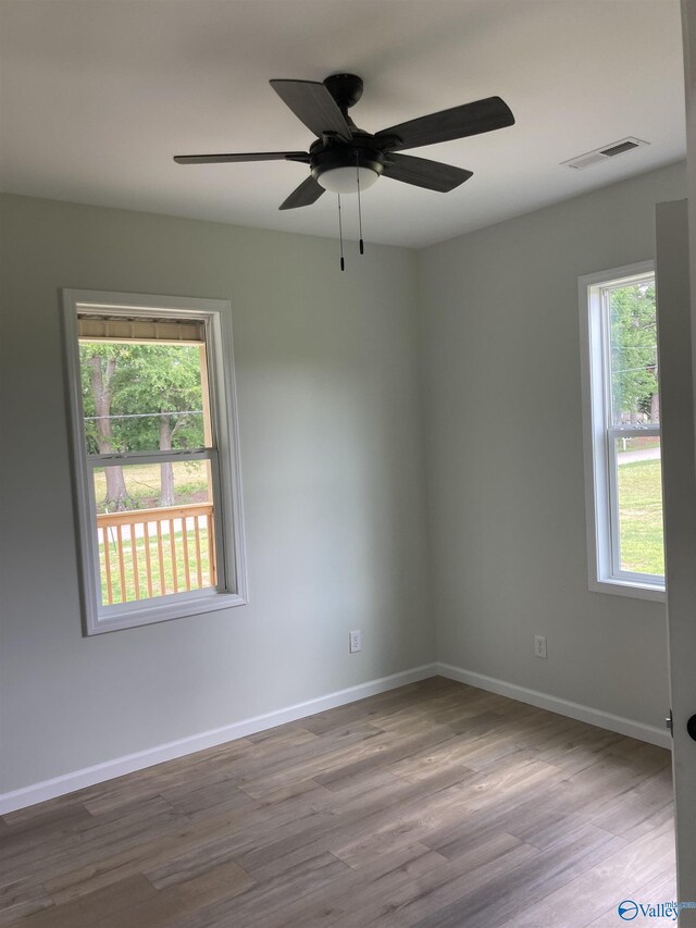 unfurnished room featuring ceiling fan, hardwood / wood-style flooring, and a wealth of natural light