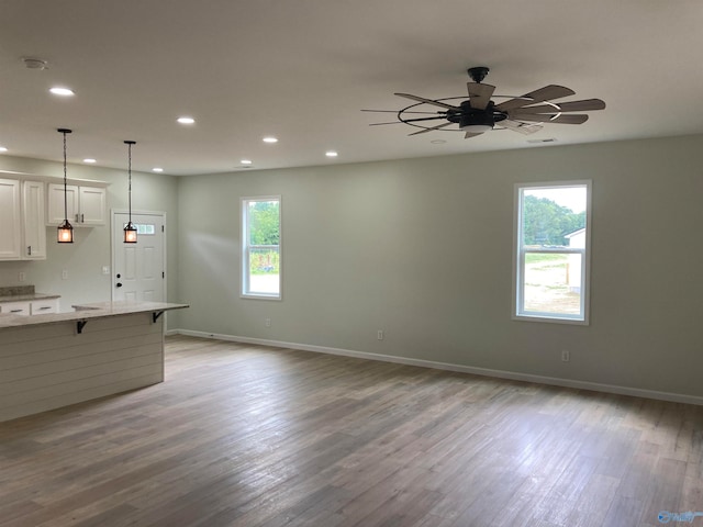 unfurnished living room with light wood-type flooring and ceiling fan