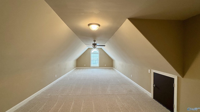 additional living space with light colored carpet and vaulted ceiling