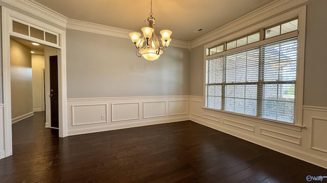 spare room with ornamental molding, dark hardwood / wood-style floors, and a notable chandelier