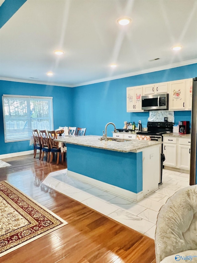 kitchen with sink, crown molding, decorative backsplash, a center island with sink, and white cabinets