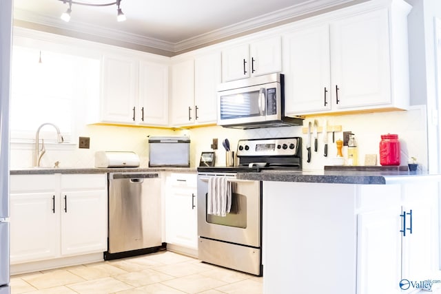1508 Berrivine Dr, Hartselle, AL 35640 - kitchen featuring appliances with stainless steel finishes, white cabinets, ornamental molding, and decorative backsplash