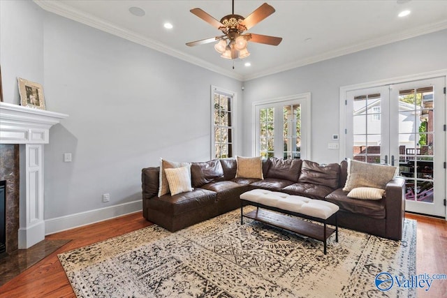 living room with crown molding, a healthy amount of sunlight, and hardwood / wood-style floors