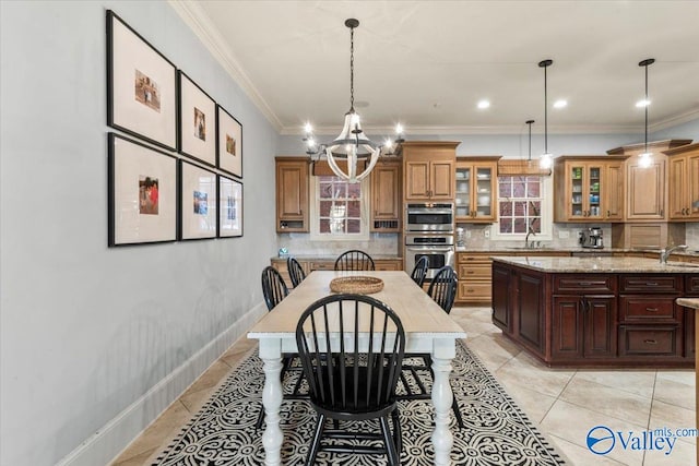 dining area featuring sink, ornamental molding, light tile patterned flooring, and an inviting chandelier