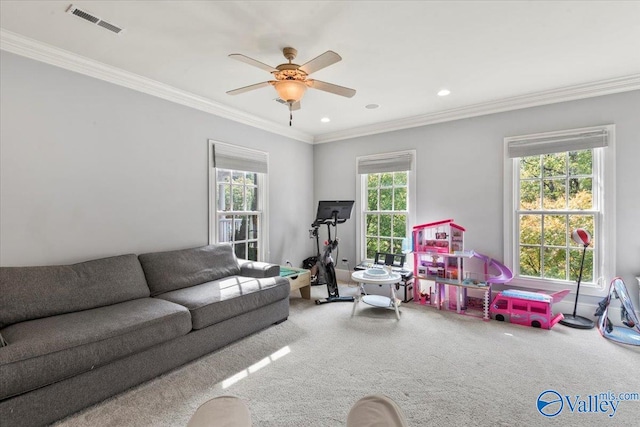 living room featuring carpet, ceiling fan, ornamental molding, and a wealth of natural light