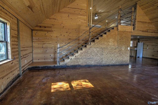 staircase with wood ceiling, wooden walls, and high vaulted ceiling