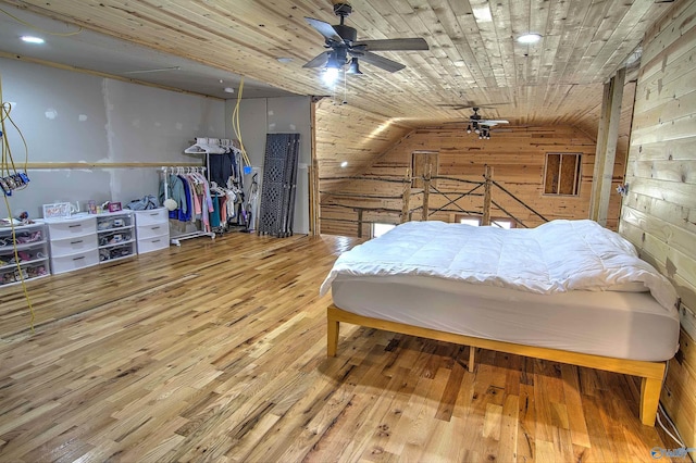 bedroom featuring wooden walls, lofted ceiling, ceiling fan, wooden ceiling, and light hardwood / wood-style flooring