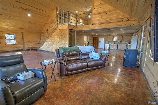 living room with high vaulted ceiling, wooden ceiling, and wood walls