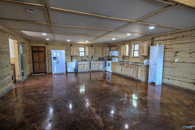 kitchen featuring sink, white appliances, and wood walls