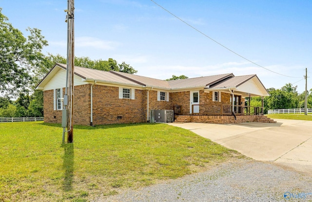 ranch-style home with cooling unit and a front yard