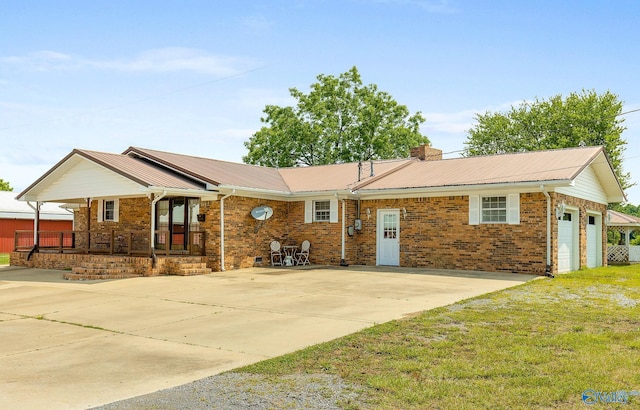 ranch-style home featuring a garage, covered porch, and a front yard