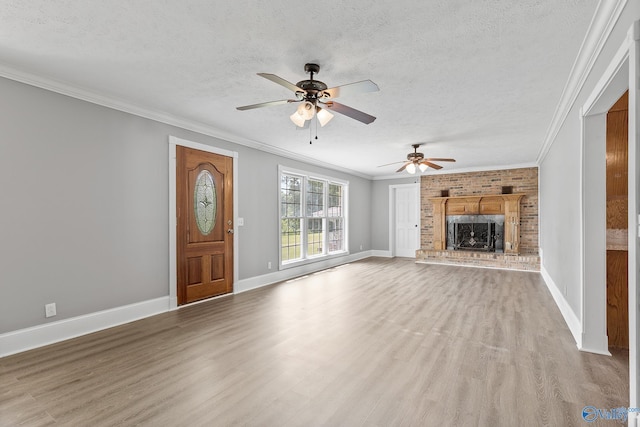 unfurnished living room featuring a textured ceiling, a brick fireplace, ceiling fan, and light wood-type flooring