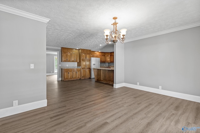 unfurnished living room featuring ornamental molding, a notable chandelier, a textured ceiling, and hardwood / wood-style flooring