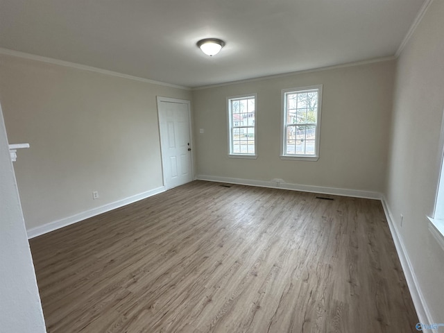 empty room with wood-type flooring and ornamental molding