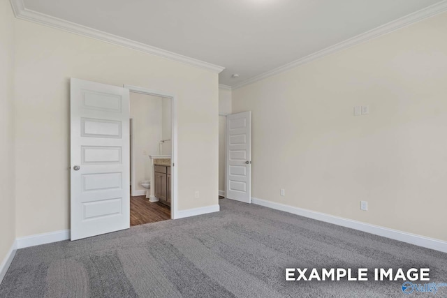 unfurnished bedroom featuring ensuite bathroom, crown molding, and dark colored carpet