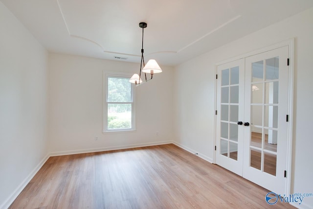 unfurnished room featuring wood finished floors, french doors, visible vents, and baseboards