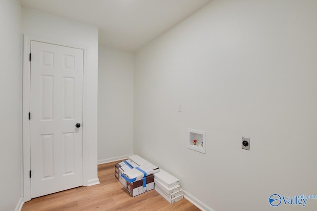 washroom with hookup for a washing machine, hookup for an electric dryer, light wood-type flooring, and baseboards