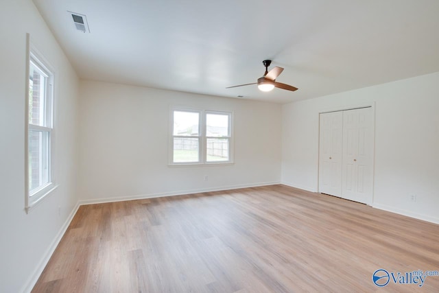 unfurnished bedroom featuring visible vents, a closet, baseboards, light wood finished floors, and a ceiling fan