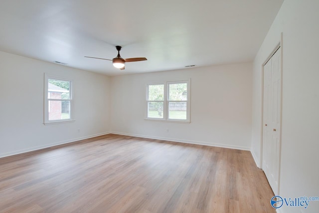 unfurnished bedroom featuring visible vents, a closet, multiple windows, and light wood-style flooring
