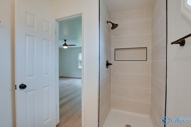 full bath with a stall shower, ceiling fan, and wood finished floors
