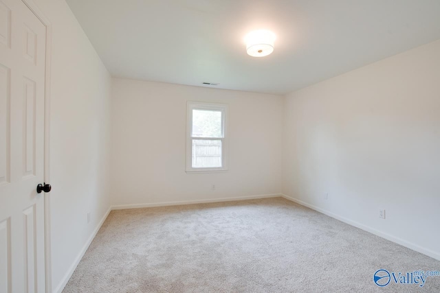 carpeted empty room with visible vents and baseboards