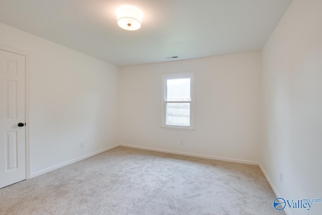 empty room featuring visible vents, carpet, and baseboards