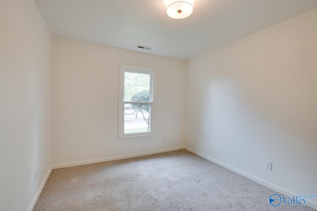 spare room with baseboards, visible vents, and carpet