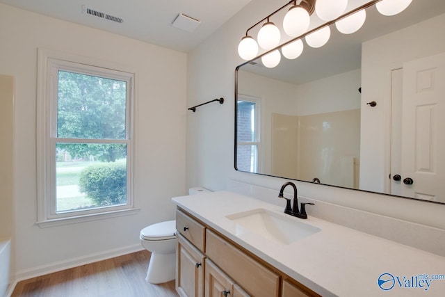 full bathroom with wood finished floors, a healthy amount of sunlight, toilet, and visible vents