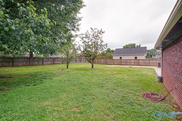 view of yard with central air condition unit and a fenced backyard