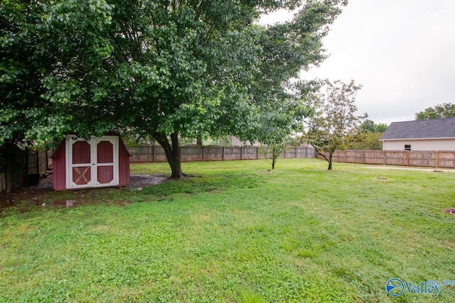 view of yard with a fenced backyard, an outbuilding, and a storage shed