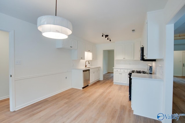 kitchen featuring stainless steel dishwasher, black gas range oven, a sink, and tasteful backsplash