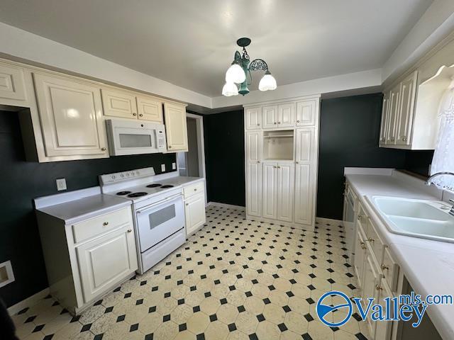 kitchen with sink, a chandelier, white appliances, and decorative light fixtures