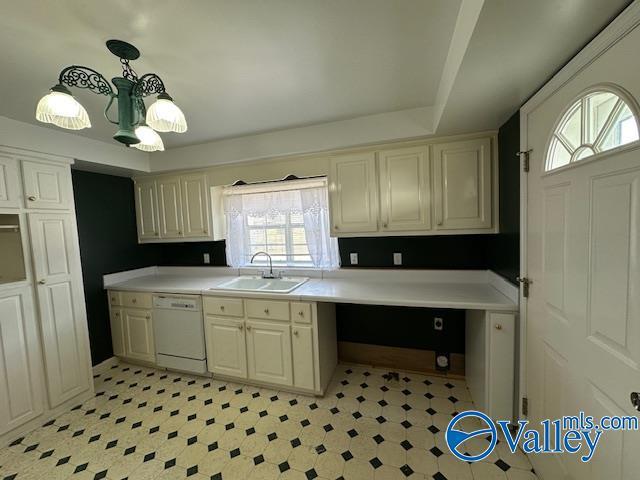 kitchen with pendant lighting, white dishwasher, and sink
