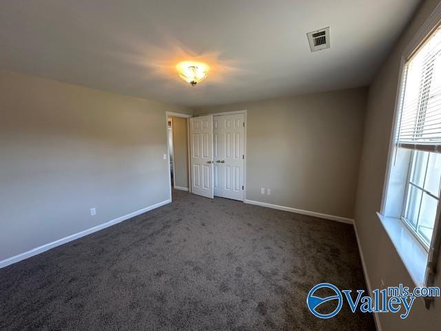 unfurnished bedroom featuring dark colored carpet