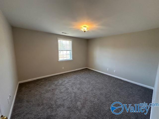 unfurnished room featuring dark carpet