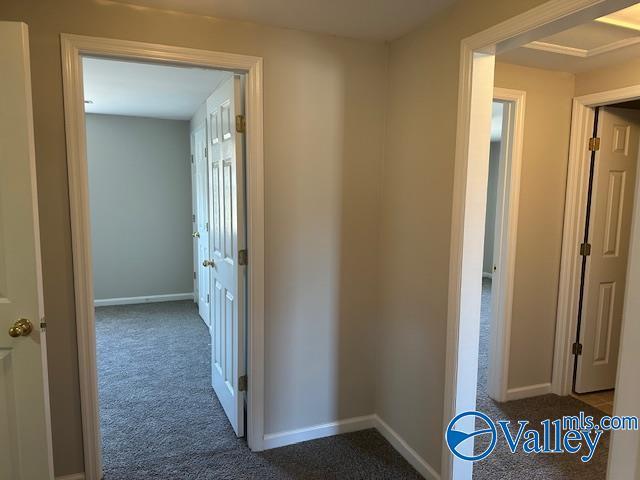 hallway featuring dark carpet