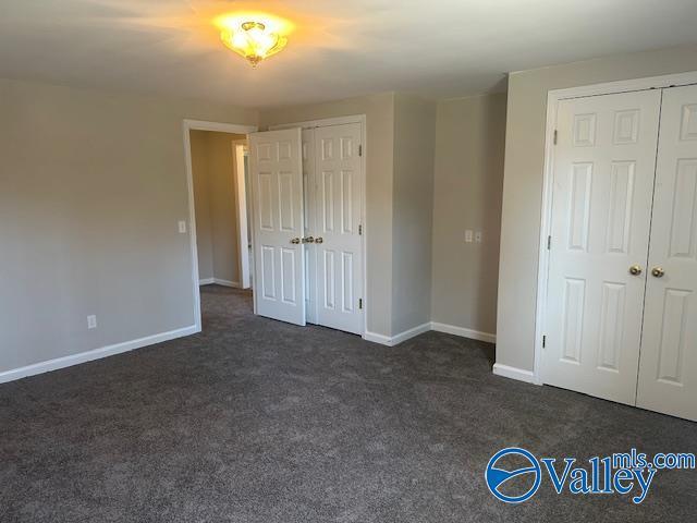 unfurnished bedroom featuring dark colored carpet