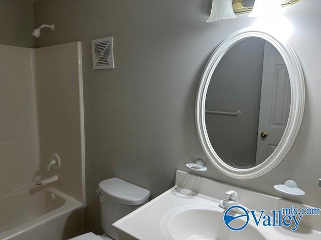 full bathroom featuring sink, shower / bathtub combination, and toilet