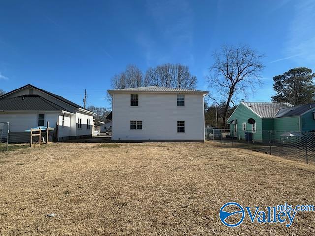 back of house with a lawn
