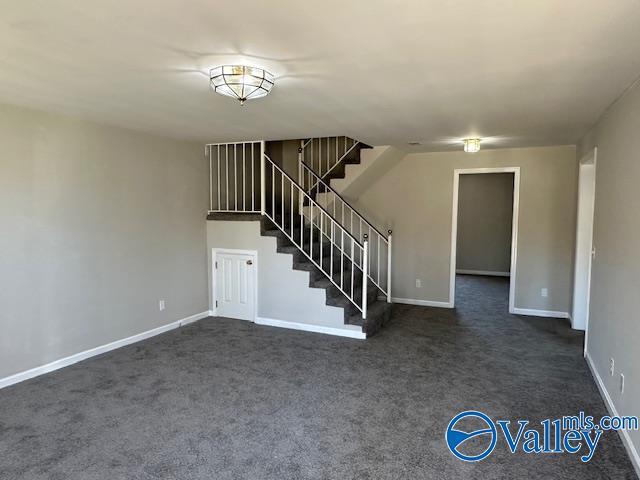 unfurnished living room with dark colored carpet