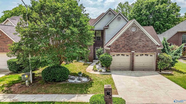 106 Spinnaker Ridge Dr, Huntsville, AL 35824 - view of front of home featuring an attached garage, concrete driveway, a front lawn, and brick siding