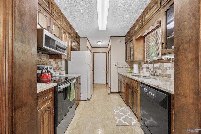 2009 Rangewood Cir, Huntsville, AL 35803 - kitchen featuring stainless steel appliances, a sink, decorative backsplash, glass insert cabinets, and a textured ceiling