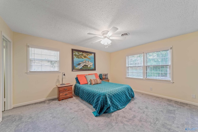 bedroom featuring a textured ceiling, carpet flooring, a ceiling fan, and baseboards