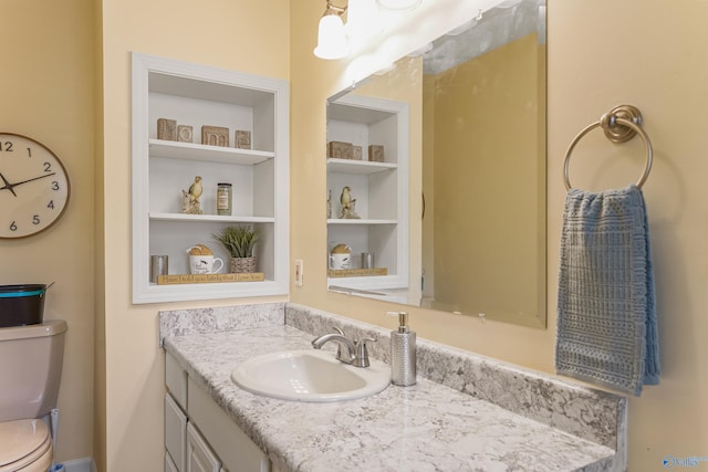 bathroom featuring vanity, toilet, and built in features