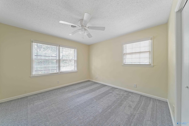 unfurnished room featuring a textured ceiling, carpet floors, ceiling fan, and baseboards