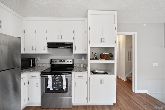 kitchen featuring a textured ceiling, under cabinet range hood, wood finished floors, white cabinetry, and appliances with stainless steel finishes