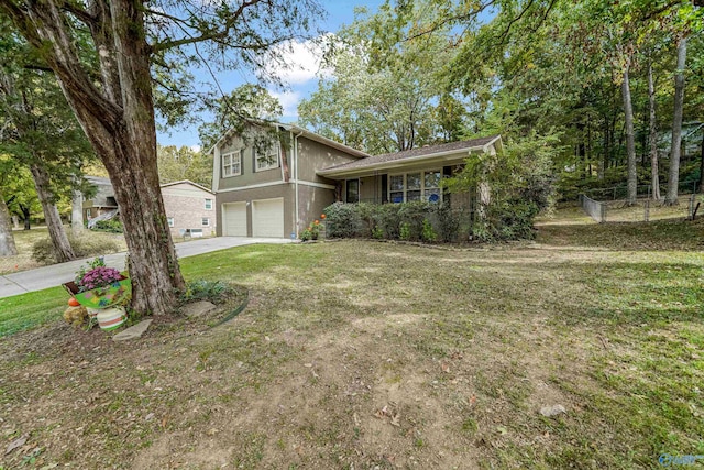 split level home with stucco siding, concrete driveway, a front yard, fence, and a garage