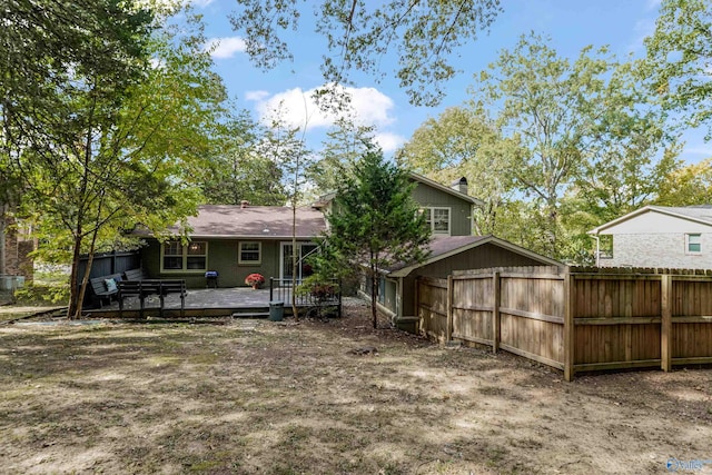 rear view of house featuring fence and a wooden deck